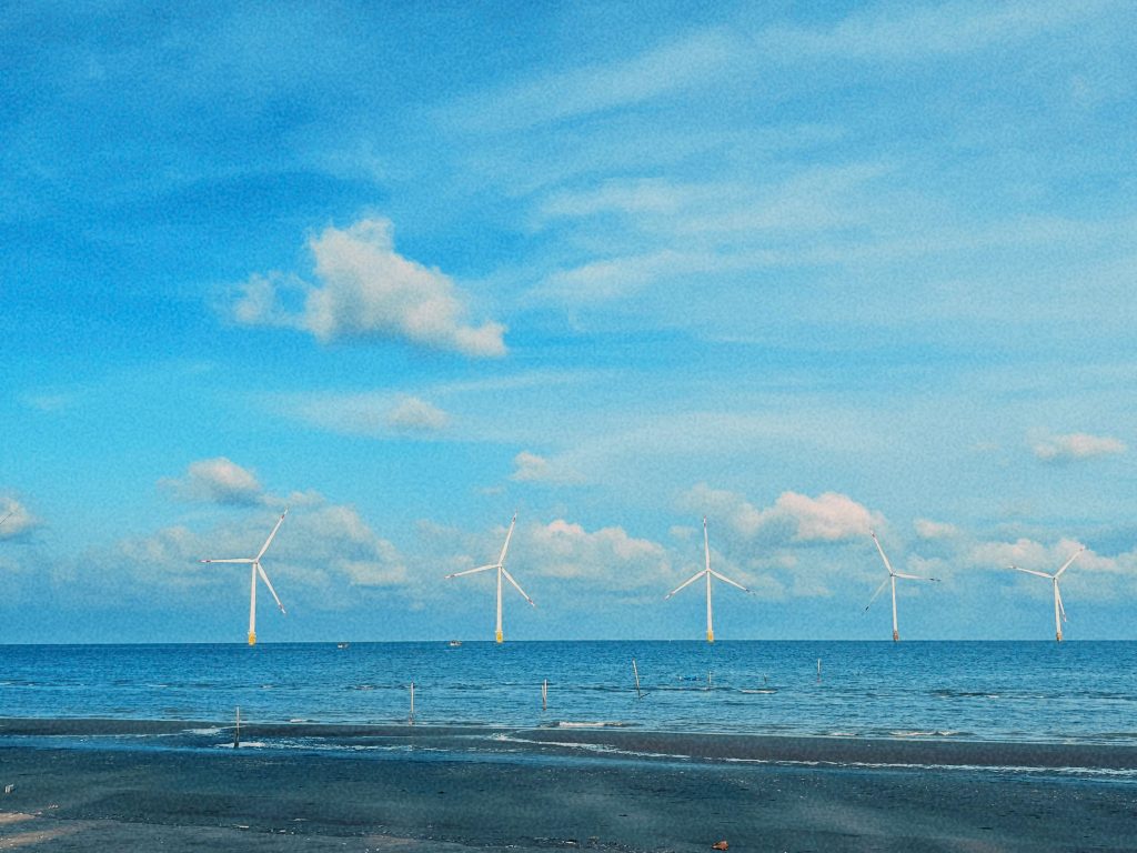 Khung cảnh biển Ba Động với trời xanh trong và mây trắng bồng bềnh, mang đến cảm giác yên bình và thư thái